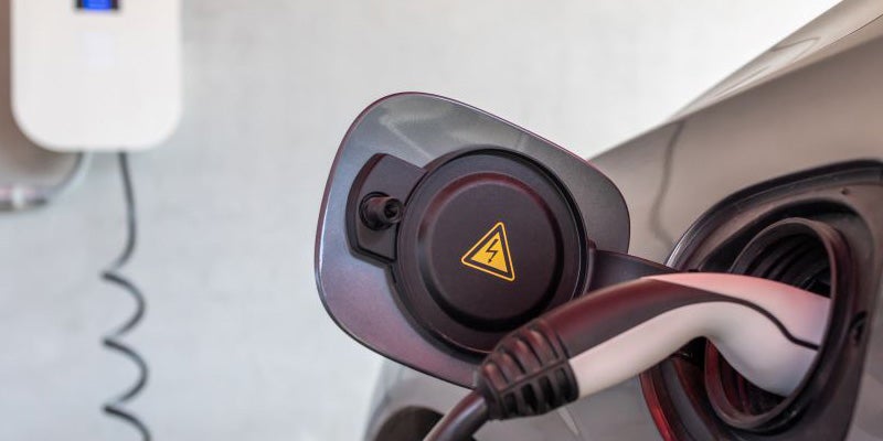 Close up of an electric vehicle charging in a home garage