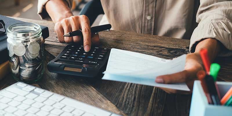 Close up of a man using a calculator at a desk